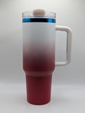 A travel tumbler with a frosted white to deep red gradient finish, featuring a white handle, a clear lid with a beige cap, and a blue accent ring near the top.